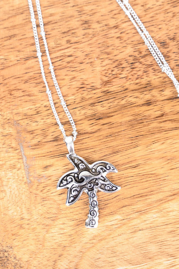 https://www.wholesaleaccessorymarket.com/cdn/shop/products/an3052-asindigo-cove-silvertone-palm-tree-necklace-928834_600x.jpg?v=1684867890